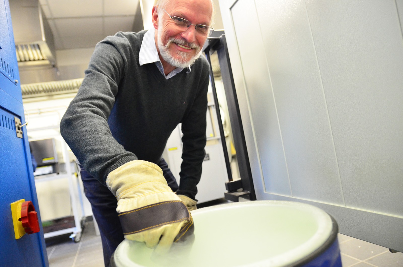Prof. Dr. Jürgen Peterseim hält ein Messer in den Dampf des siedenden Flüssigstickstoffs.