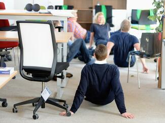 Was machen die denn da im Büro? Zum gesünderes Verhalten am Arbeitsplatz gehört auch die eine oder andere Fitnessübung. 