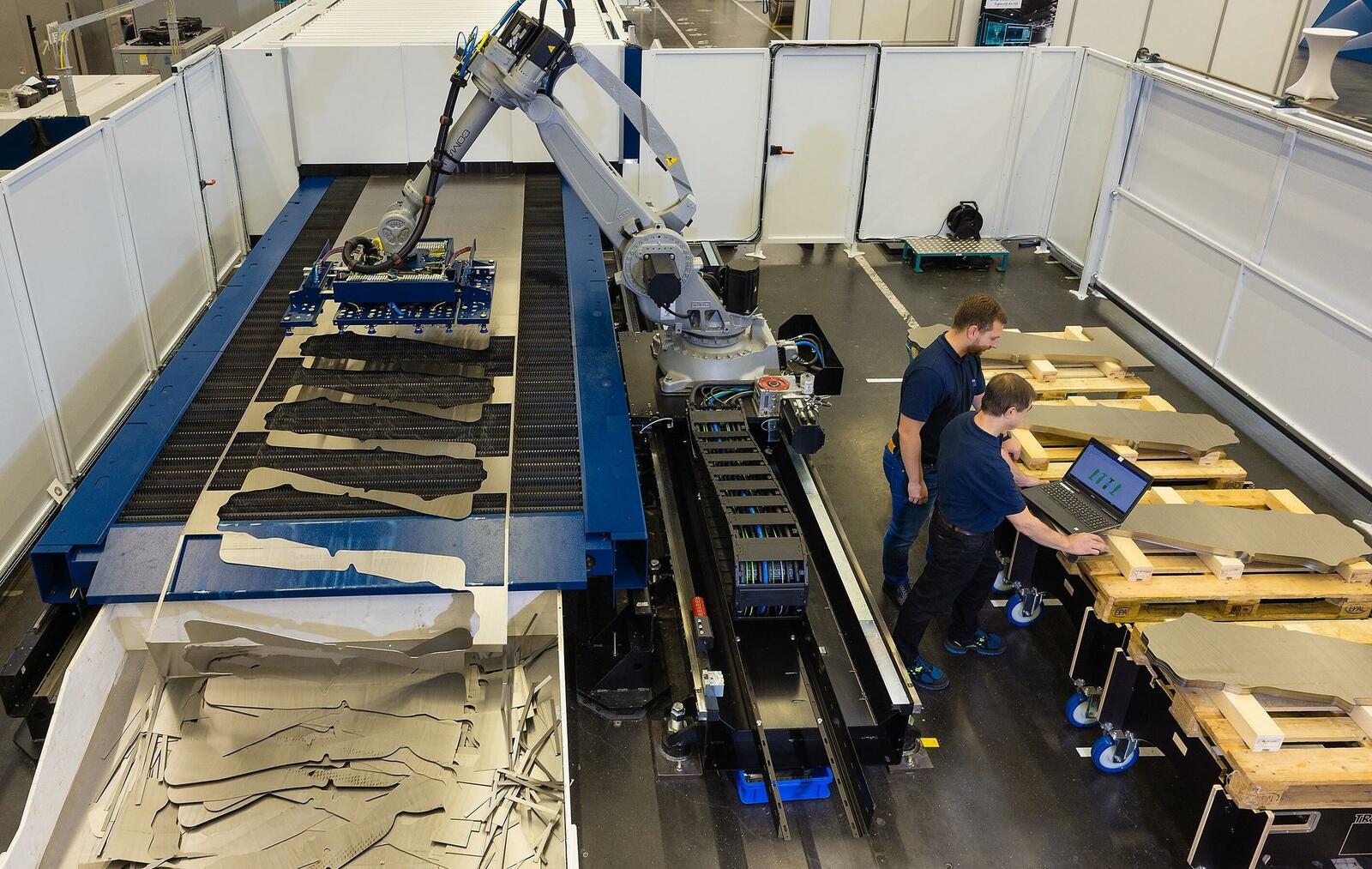 Zwei Mitarbeiter bereiten die Laser-Blanking-Line für ihren vollautomatischen Einsatz vor. 