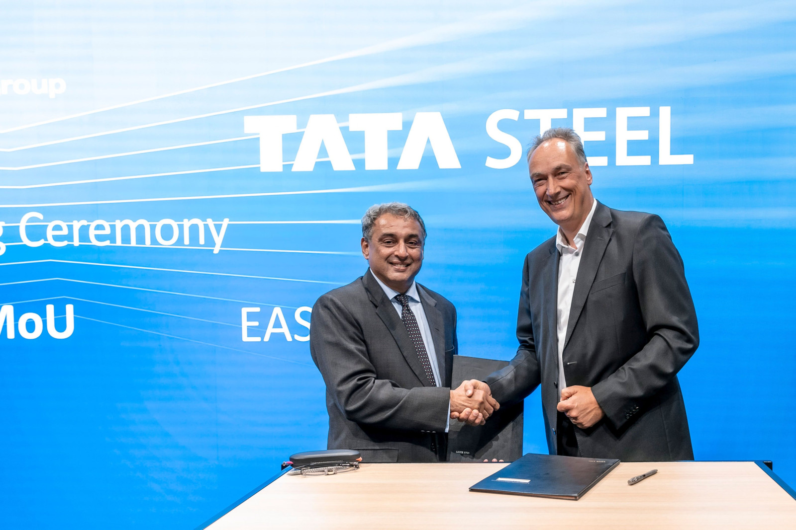 T.V. Narendran (links), CEO, Tata Steel, und Burkhard Dahmen (rechts), CEO, SMS Group, feiern die Unterzeichnung der Absichtserklärung mit ihren Delegationen auf der Metec in Düsseldorf.