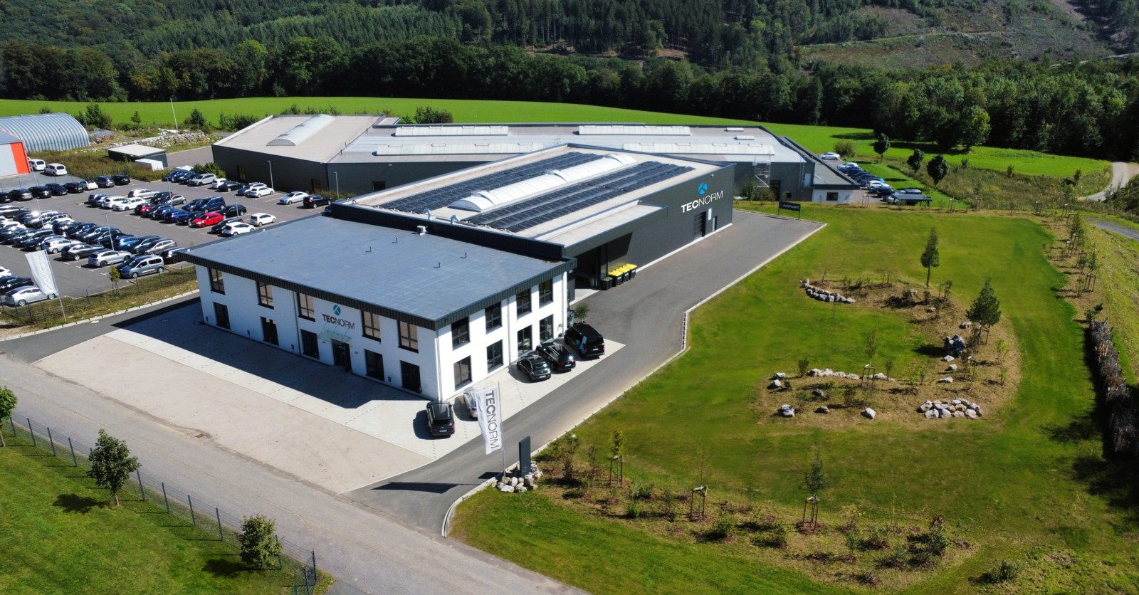Das neue Betriebsgebäude der Tecnorm – Genügend Raum für umfangreiche Lagerhaltung und effiziente Prozesse sowie ergonomische Arbeitsplätze für das Team – in einer klimafreundlichen Hülle mit großem Garten zum CO